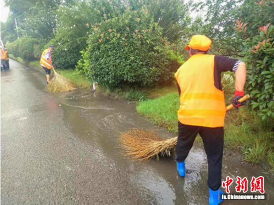 清洁工清扫积水路面。