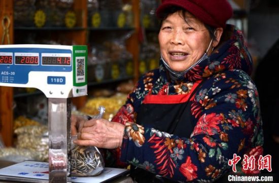 徐州市区一邳州炒货店,韩老太太把瓜子称重以后,为顾客打包。 朱志庚 摄 徐州市区一邳州炒货店,韩老太太把瓜子称重以后,为顾客打包。 朱志庚 摄