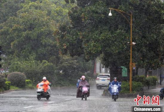 7月27日,台风“烟花”来袭,扬州市民在风雨中骑行。 孟德龙 摄 7月27日,台风“烟花”来袭,扬州市民在风雨中骑行。 孟德龙 摄