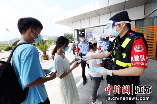8月18日,执勤民警正在向进站乘客发放口罩,提醒大家做好自我防护。赵振伟 摄 8月18日,执勤民警正在向进站乘客发放口罩,提醒大家做好自我防护。赵振伟 摄