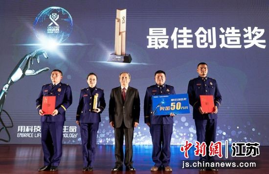 王民董事长为获得最佳创造奖(消防赛题)选手颁发奖杯以及50万元奖金。 冯若宇 摄 王民董事长为获得最佳创造奖(消防赛题)选手颁发奖杯以及50万元奖金。 冯若宇 摄