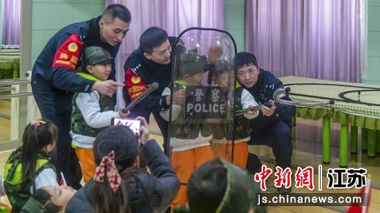民警带领孩子们体验反恐装备。黄培 摄 民警带领孩子们体验反恐装备。黄培 摄
