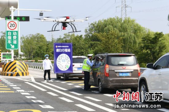 在盐靖高速盐城西出口,盐城警方使用无人机悬挂行程码供驾乘人员使用。盐城市委宣传部供图 在盐靖高速盐城西出口,盐城警方使用无人机悬挂行程码供驾乘人员使用。盐城市委宣传部供图