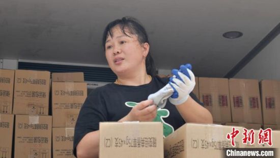 为了不耽误后续运货时间,任大清会自己戴上手套搬货。 唐霁 摄 为了不耽误后续运货时间,任大清会自己戴上手套搬货。 唐霁 摄