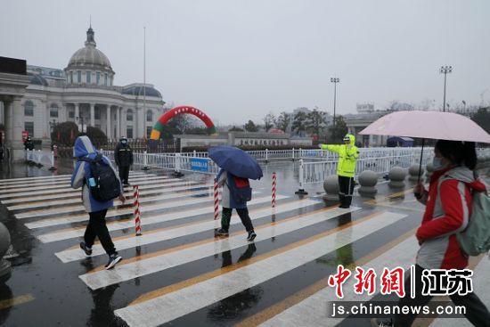 交警在学校门口雨中护学。盐城交警供图 交警在学校门口雨中护学。盐城交警供图