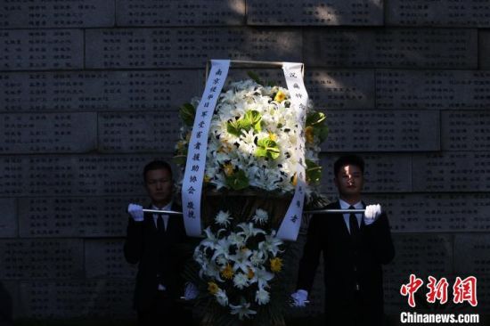 工作人员向南京大屠杀死难者敬献花圈。泱波 摄 工作人员向南京大屠杀死难者敬献花圈。泱波 摄