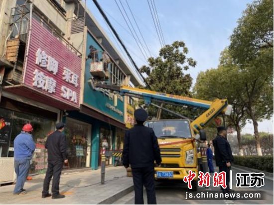 工作人员对店招标牌进行优化提升。南京江北新区管理委员会综合行政执法局供图 工作人员对店招标牌进行优化提升。南京江北新区管理委员会综合行政执法局供图