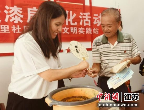 居民在志愿者指导下体验漆扇制作。张梦珠摄 居民在志愿者指导下体验漆扇制作。张梦珠摄