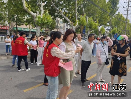 网格员在学校门口发放宣传手册。东坎街道 供图 网格员在学校门口发放宣传手册。东坎街道 供图