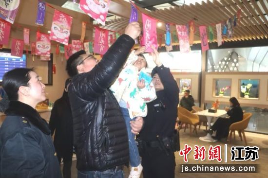 旅客参与猜灯谜活动。 王召辉 摄 旅客参与猜灯谜活动。 王召辉 摄