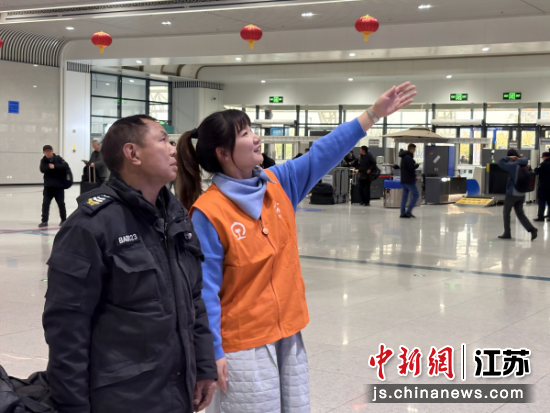 “小甜橙”志愿者在为旅客指引观看车次屏。宋潇璇 摄 “小甜橙”志愿者在为旅客指引观看车次屏。宋潇璇 摄